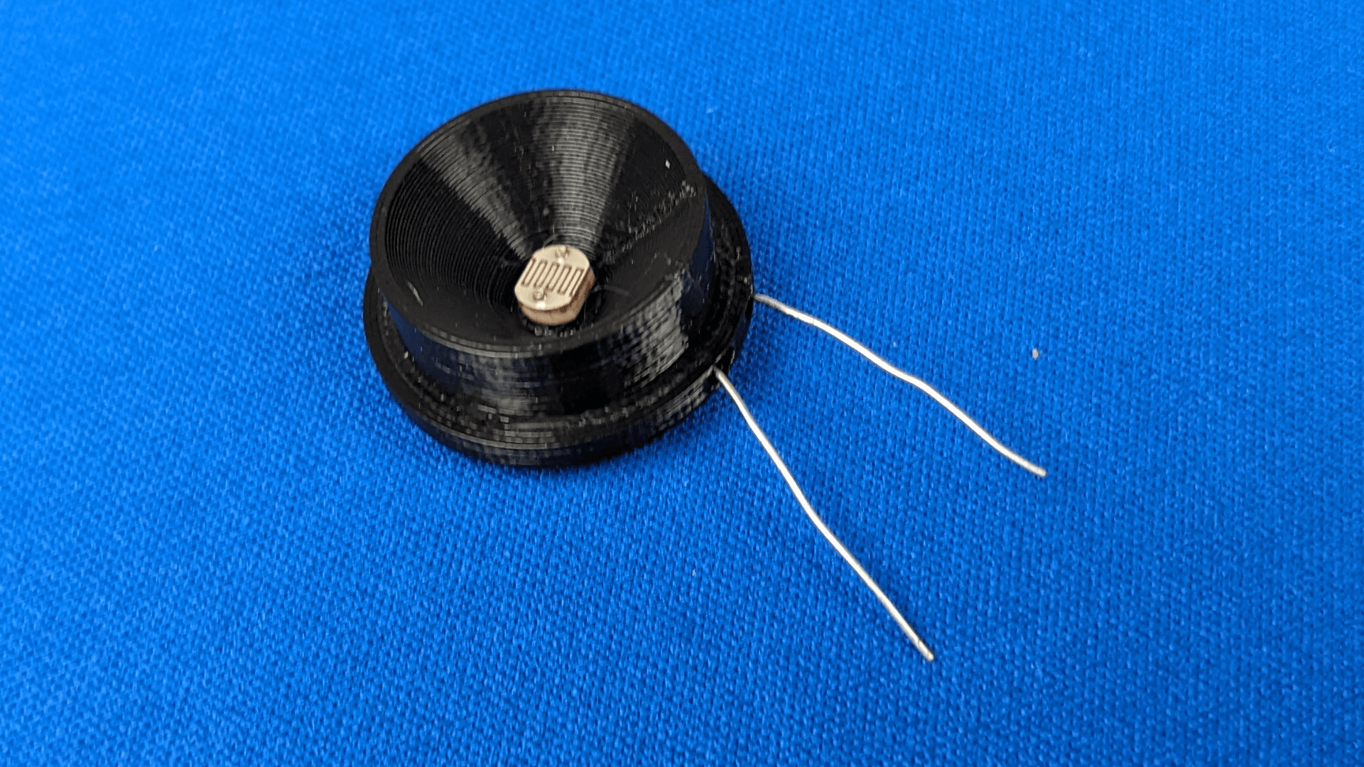 A picture of a photoresistor embedded in a 3d printed housing Photoresistor